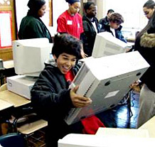 A delighted boy receives a refurbished computer at Computers for Youth
