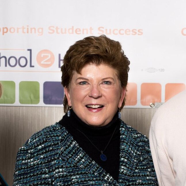 Cropped photo of Former State Sup of Public Instruction Delaine Eastin. Eastin is standing in frot of a banner at the 2017 School2Homne Leadership Academy. Above her head, on the banner, the words "Student Succes" can be read.