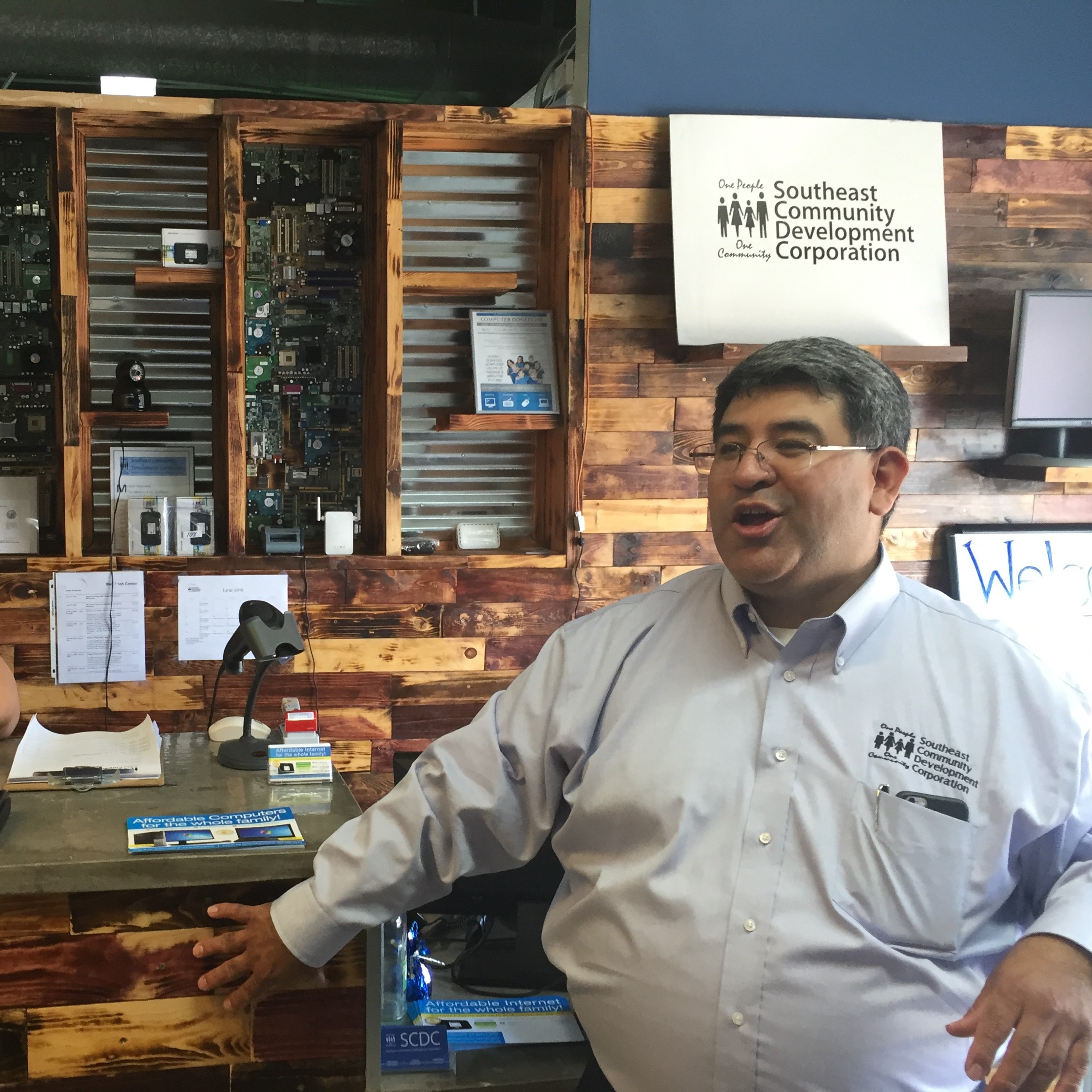 SCDC Director, Cesar Zaldivar-Motts stands at the wooden bar of SCDC's Internet Cafe